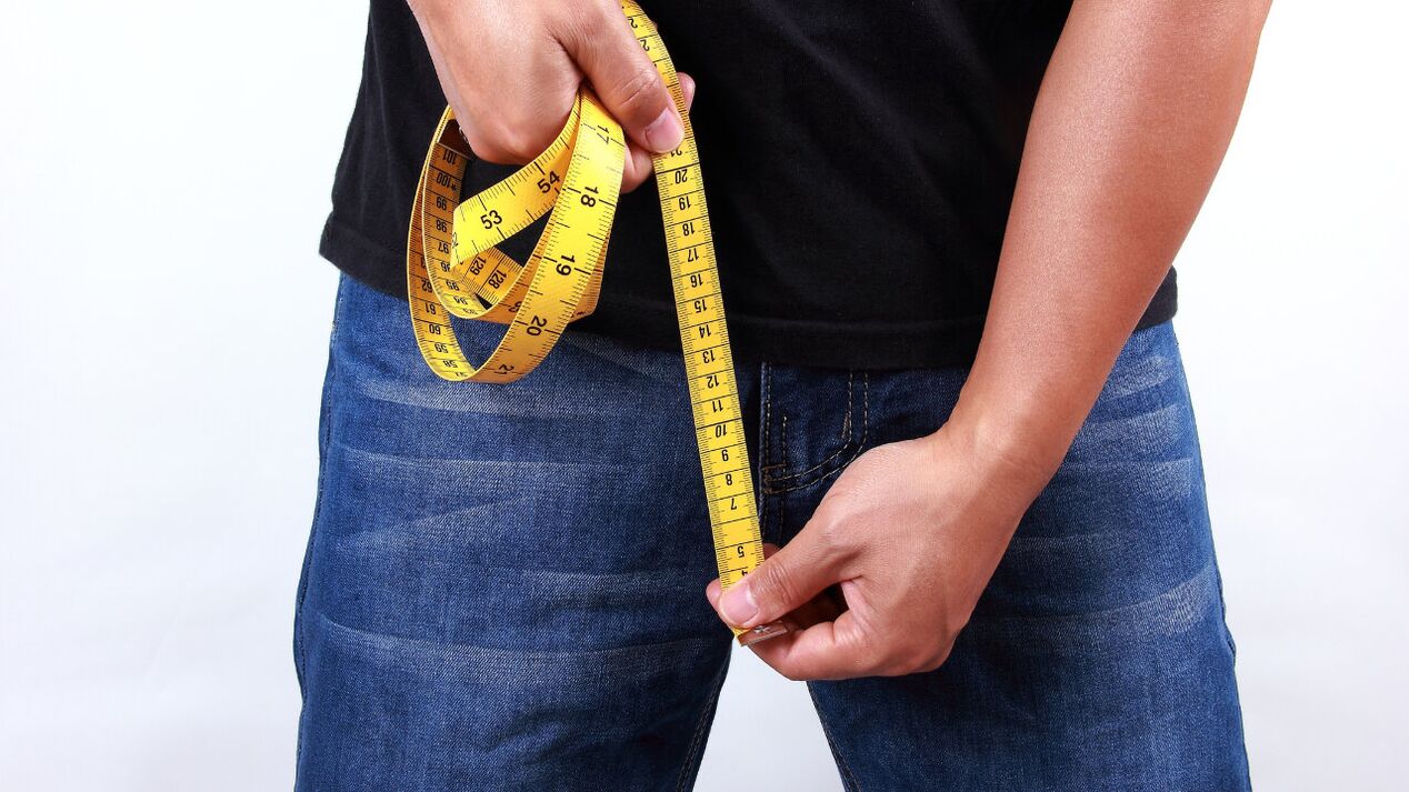 A man measures his penis before it enlarges