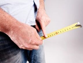 A man measures the length of his penis before enlarging it with soda