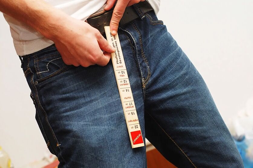 A man measures his penis before it enlarges